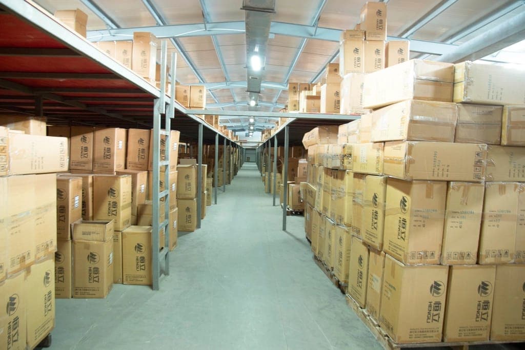 Warehouse aisle lined with stacked cartons
